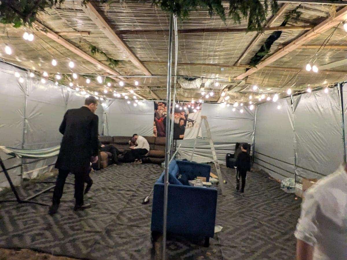Finished custom sukkah interior with carpeting, tarp walls, schach, and overhead lighting