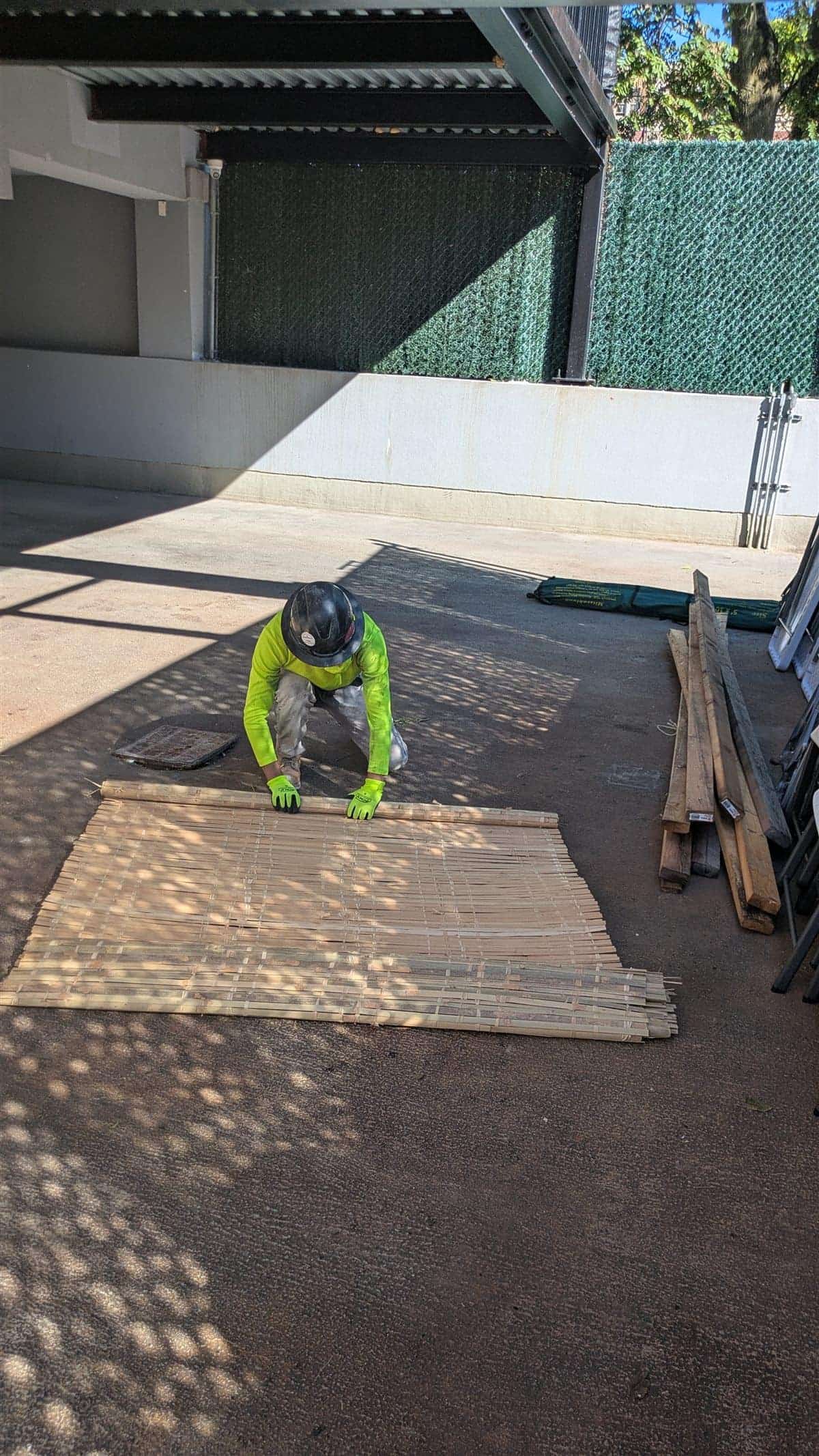 A team member preparing bamboo schach for a sukkah