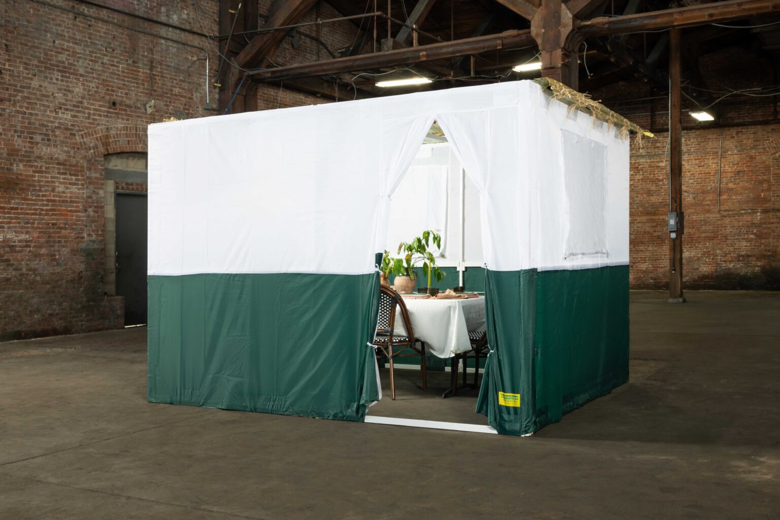 Completed sukkah with two-tone canvas walls and a framed entrance