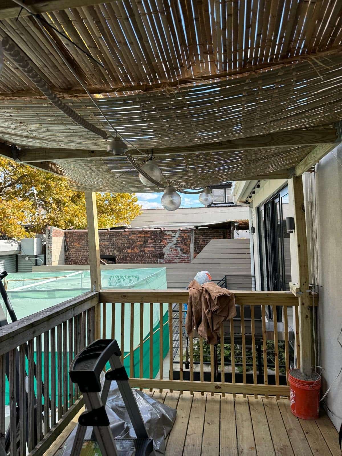 House-attached porch pergola with bamboo schach and hanging lights