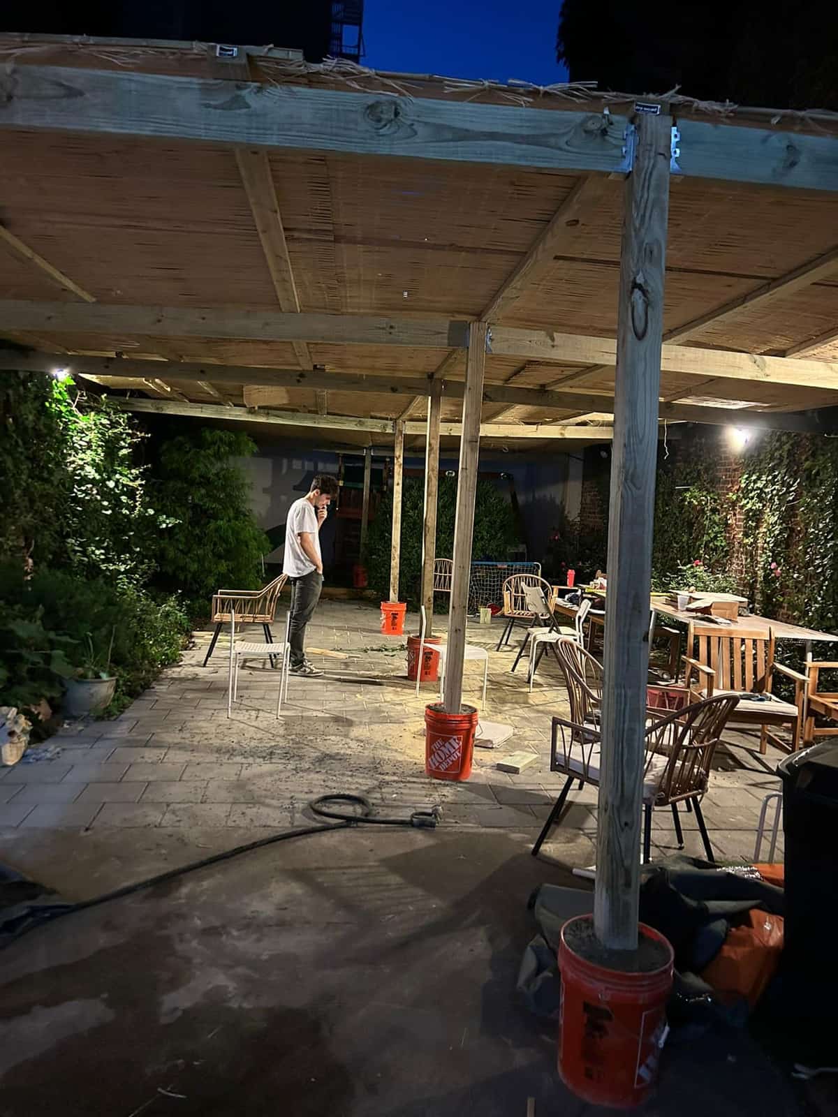 Large timber pergola over a paved courtyard with bamboo roof and integrated lighting