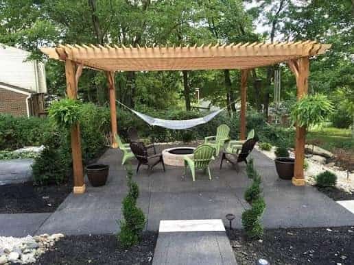 Open-sided timber pergola over garden seating and a firepit